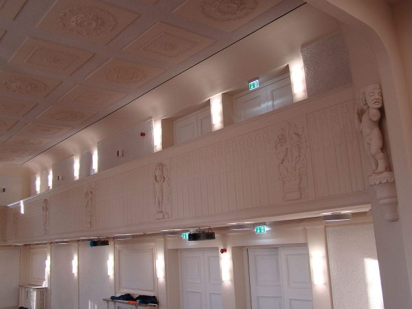 Brüstungsverkleidung mit Ornamentik und Theaterfiguren im Kreistagssaal Schloß Sonnenstein, Pirna